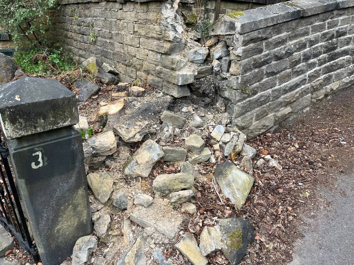 Fallen sandstone blocks heaped against the gatepost at number 3, the rest of the wall still standing