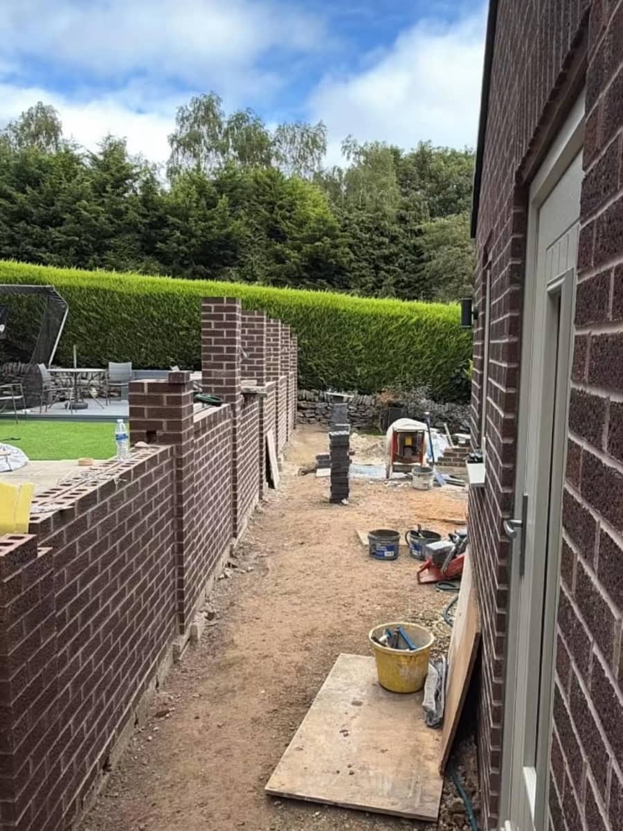 The Oxspring boundary wall under way along the side of the house, piers and a mixing tub