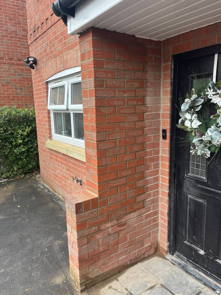 A red brick pier and side return built beside a black front door