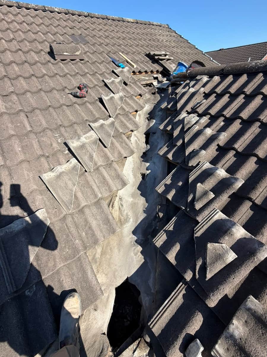 A roof valley stripped right out, the old lining exposed and the tiles lifted back either side